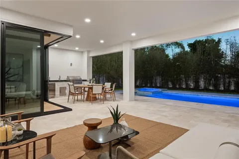 a living room with patio furniture and a floor to ceiling window