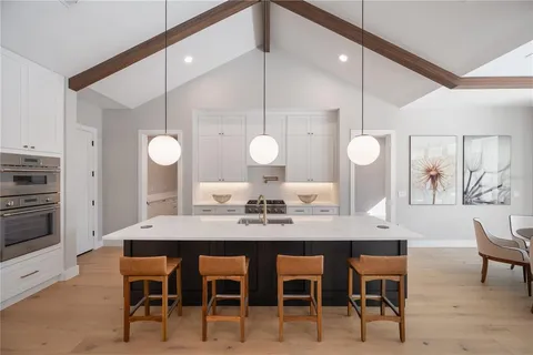 a kitchen with stainless steel appliances kitchen island a table and chairs in it