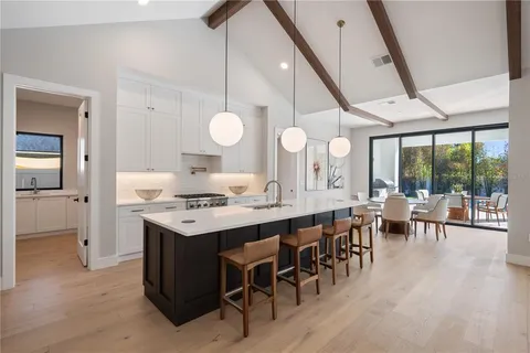 a open kitchen with a dining table chairs and white cabinets