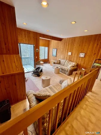 a kitchen with stainless steel appliances kitchen island granite countertop wooden cabinets a couch and a large window