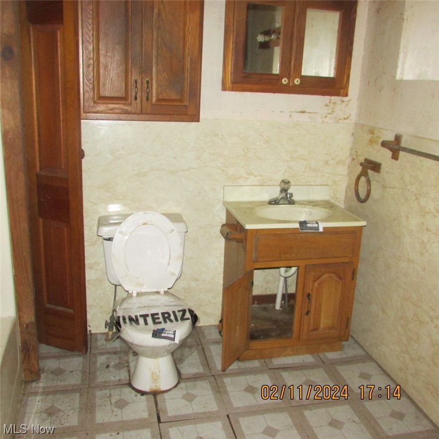 Bathroom featuring tile floors, vanity, and toilet