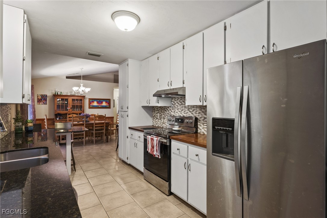 571 2nd Street Southeast Naples, FL 34117 - Photo 8 of 31 a kitchen with stainless steel appliances granite countertop a refrigerator oven a sink dishwasher and white cabinets next to a window