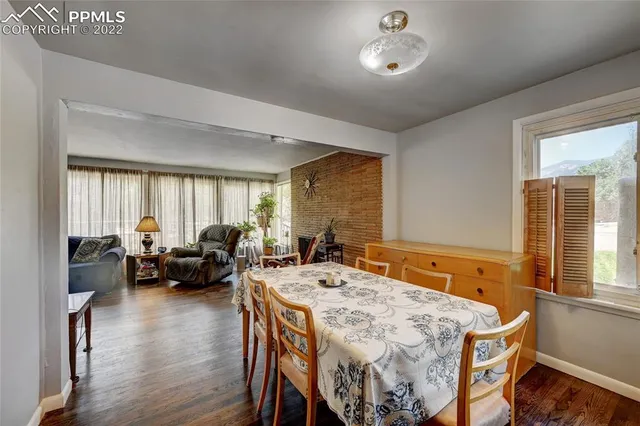 a living room with furniture two window and wooden floor