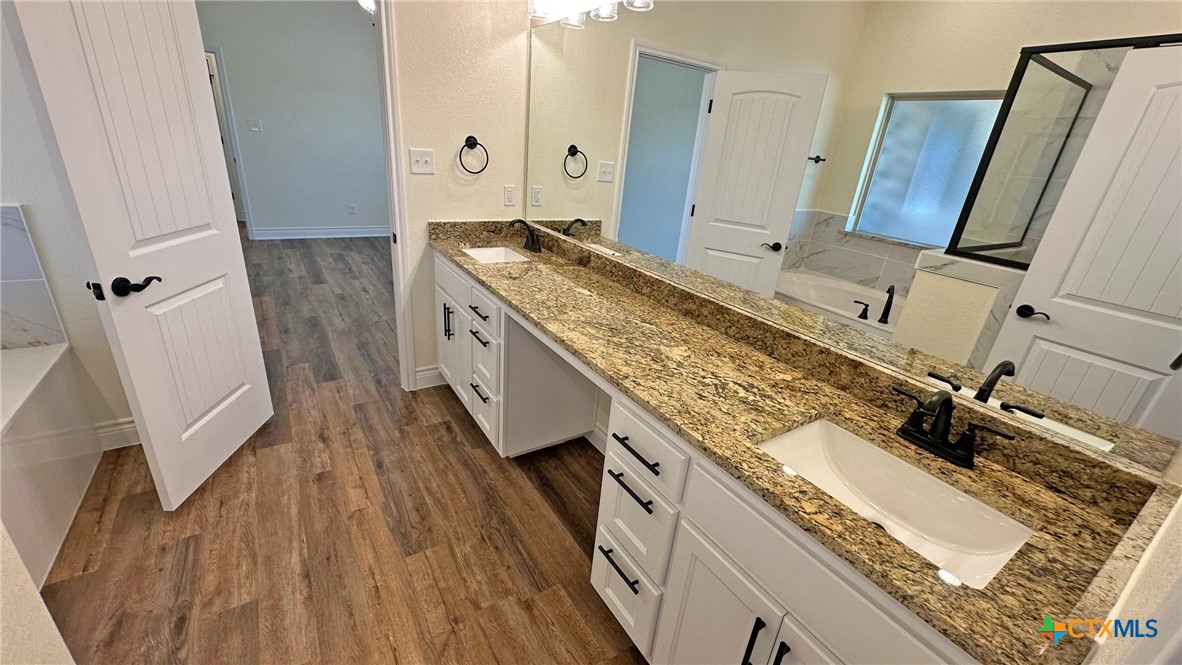 4237 Cool Basin Road Kempner, TX 76539 - Photo 34 of 36 a spacious bathroom with a granite countertop sink and a mirror