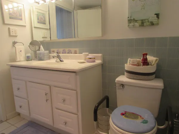 a bathroom with a granite countertop toilet sink and mirror