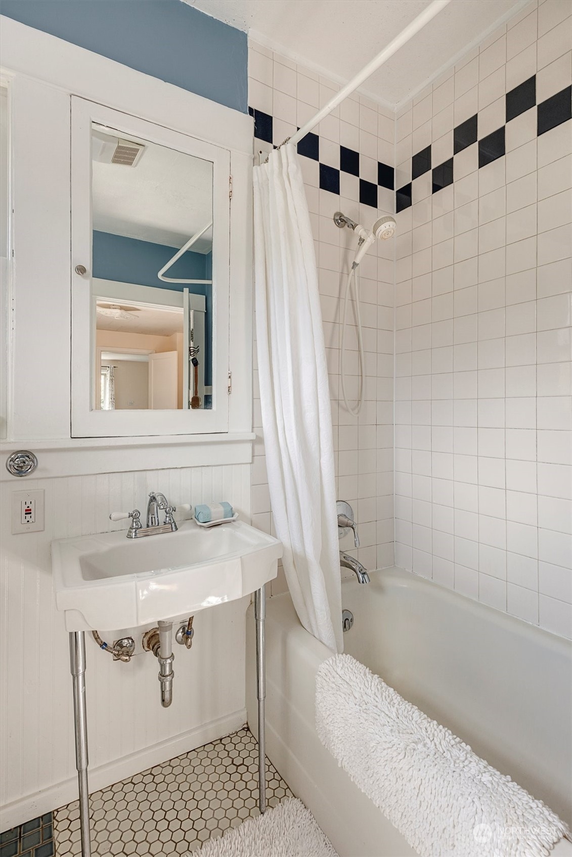 5051 40th Avenue Southwest Seattle, WA 98136 - Photo 25 of 40 a bathroom with a sink a mirror a bathtub and shower