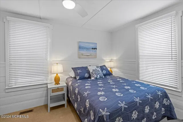 a large bed sitting in a bedroom next to a window and lamp