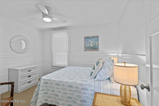 a bedroom with a bed a lamp and a dresser