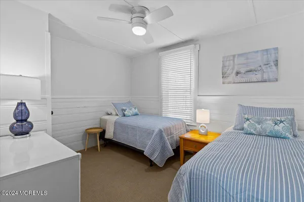 a bedroom with two beds and painting on the wall