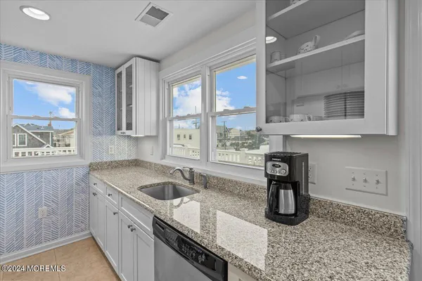 a kitchen with stainless steel appliances granite countertop a sink a stove and a counter space