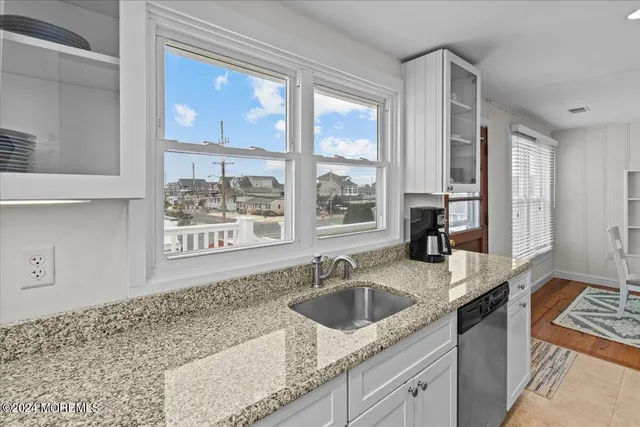 a kitchen with stainless steel appliances granite countertop a sink a stove and a counter space