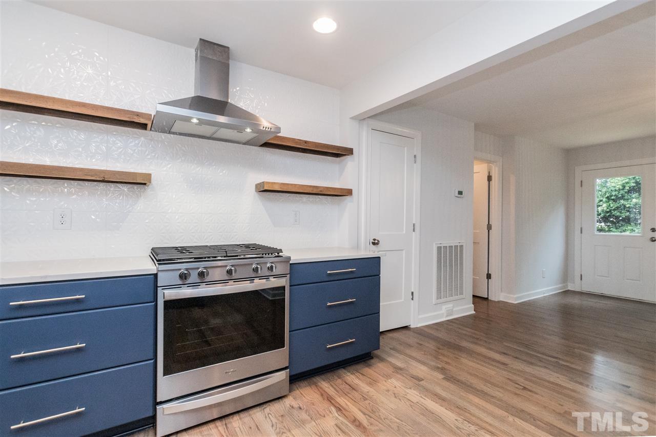 915 Elm Street Raleigh, NC 27604 - Photo 11 of 25 a kitchen with a stove and white cabinets