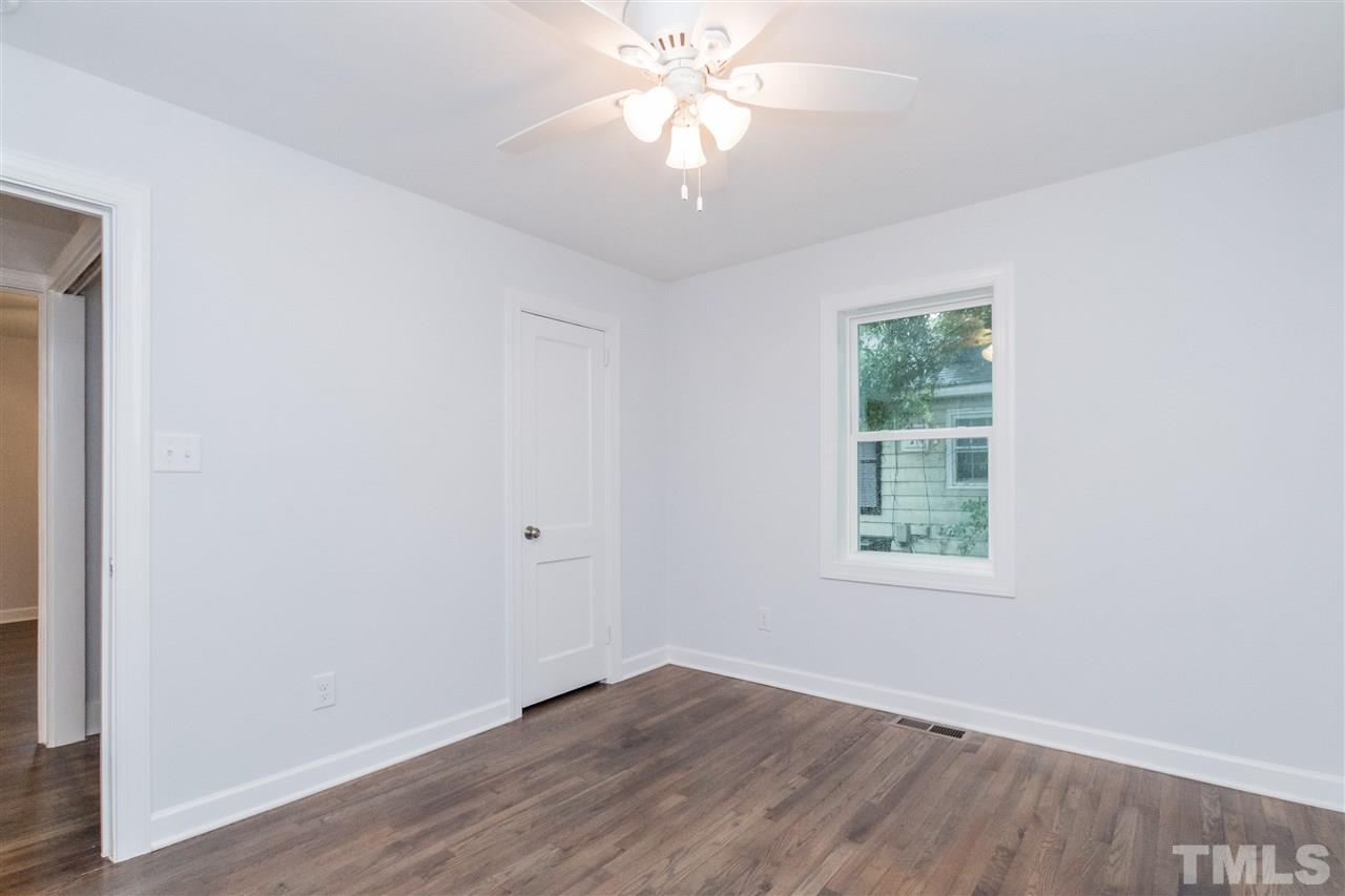 915 Elm Street Raleigh, NC 27604 - Photo 21 of 25 an empty room with wooden floor chandelier fan and windows