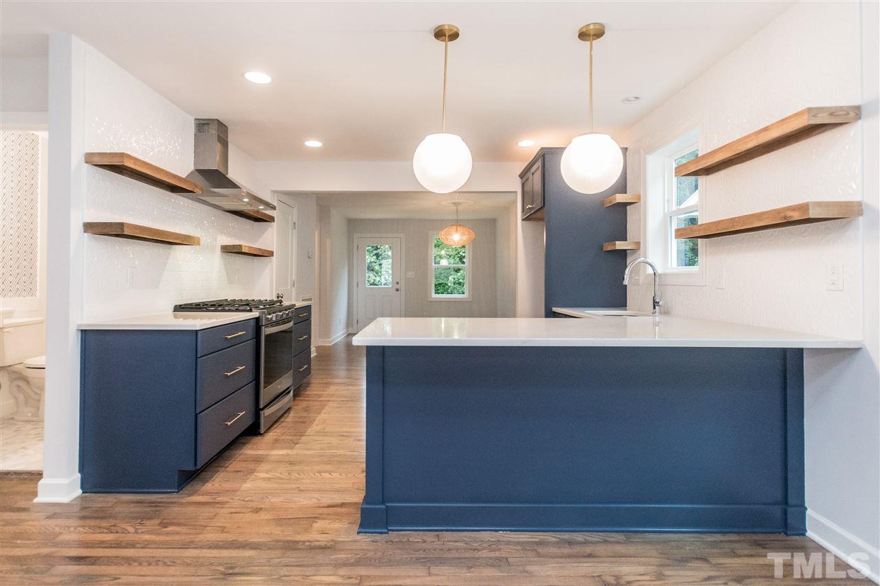 915 Elm Street Raleigh, NC 27604 - Photo 7 of 25 a large kitchen with granite countertop a stove a sink a center island and wooden floor