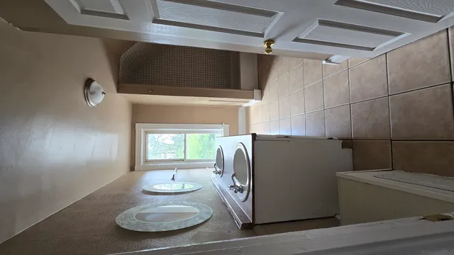 a kitchen with stainless steel appliances granite countertop a refrigerator a sink dishwasher a stove and white countertops with wooden floor