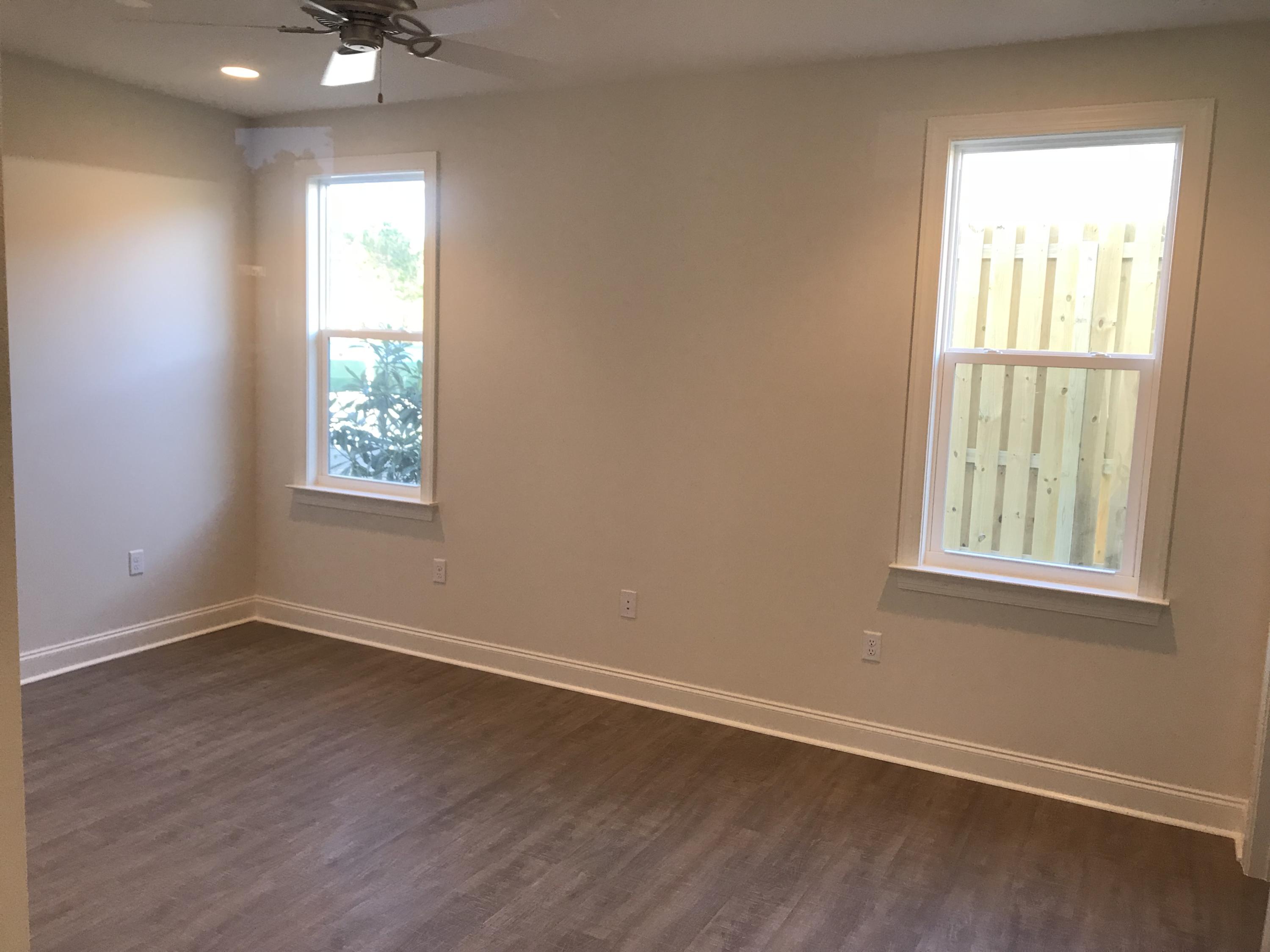 213 Chapman Street Santa Rosa Beach, FL 32459 - Photo 11 of 30 an empty room with wooden floor and windows