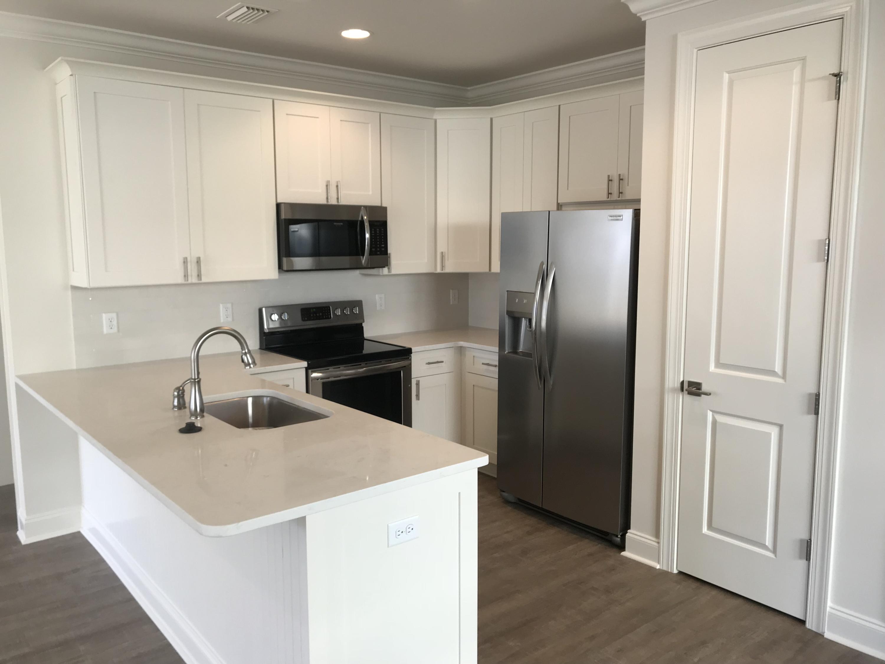 213 Chapman Street Santa Rosa Beach, FL 32459 - Photo 5 of 30 a kitchen with a sink a refrigerator and cabinets