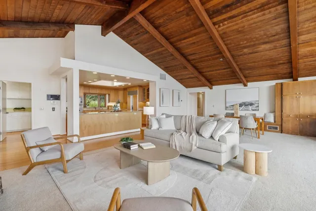 a view of a kitchen with kitchen island a stove a refrigerator a dining table and chairs with wooden floor