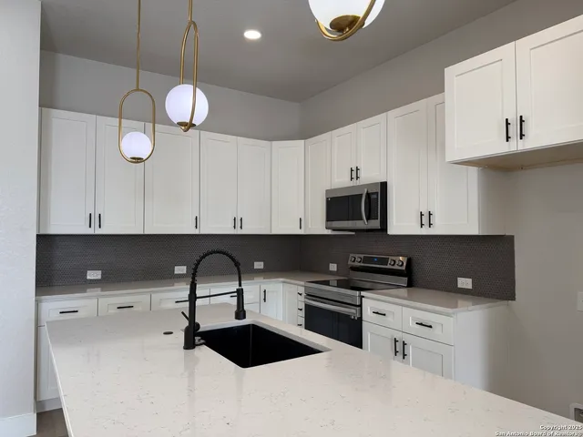 a kitchen with cabinets appliances and a sink