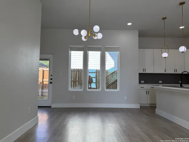 a kitchen with a wooden floor and a large window