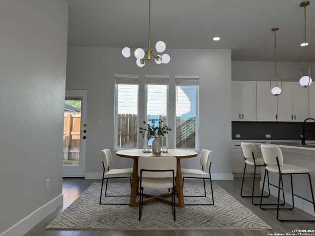 a dining room with wooden floor a chandelier a wooden table and chairs