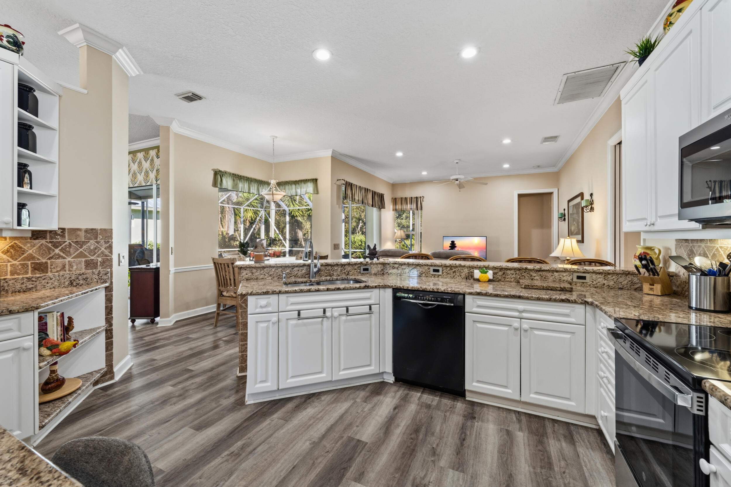 768 Southwest Whisper Ridge Trail Palm City, FL 34990 - Photo 12 of 40 a large kitchen with stainless steel appliances granite countertop a stove and a sink