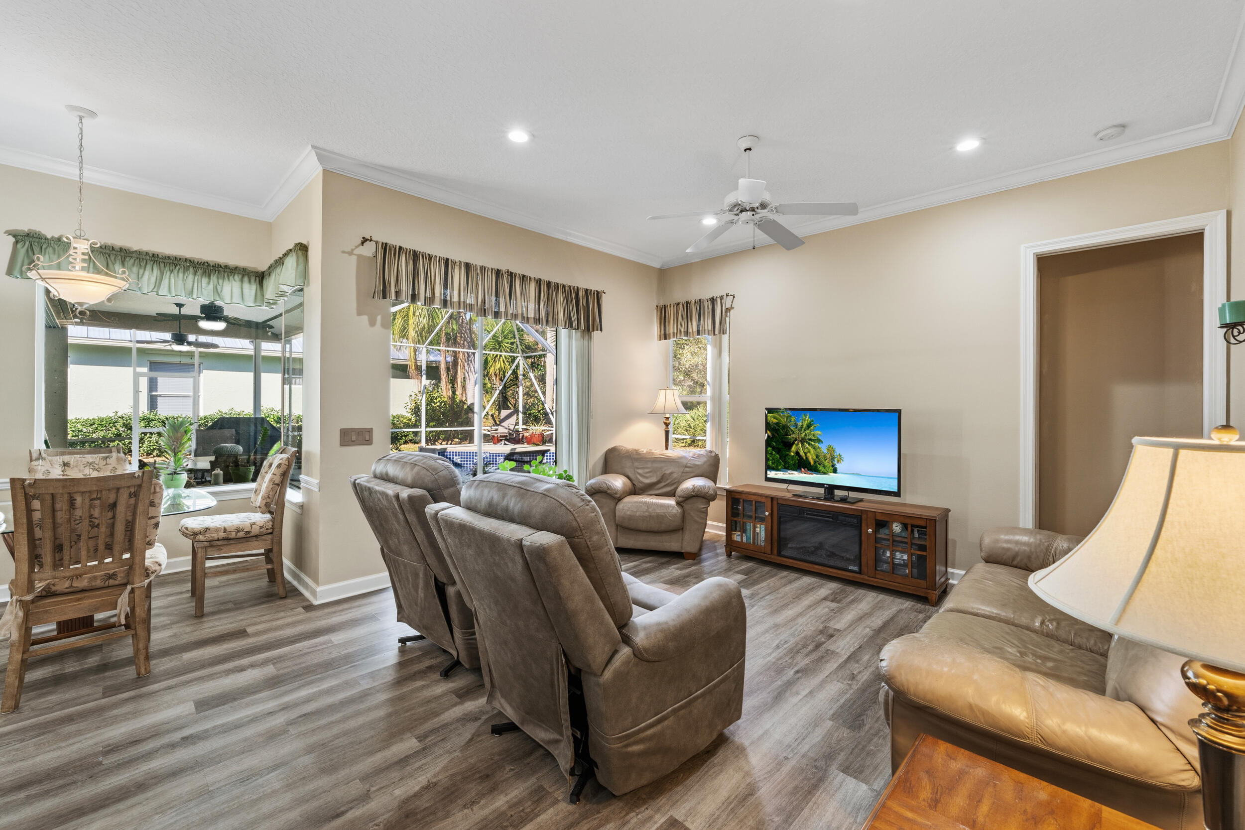768 Southwest Whisper Ridge Trail Palm City, FL 34990 - Photo 8 of 40 a living room with furniture a flat screen tv and a large window