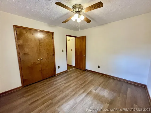 a view of a livingroom with a chandelier fan and a hallway