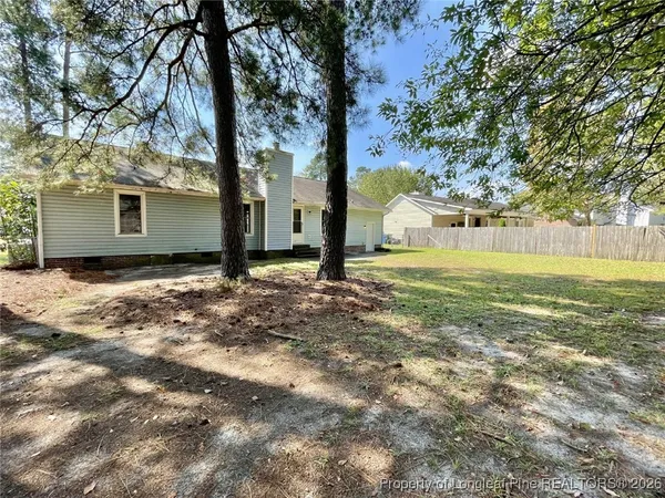 a view of a house with backyard and tree