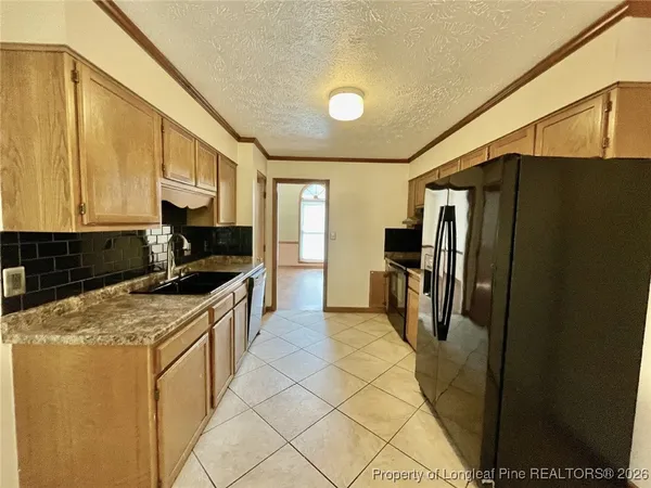 a kitchen with stainless steel appliances granite countertop a refrigerator a stove and a sink
