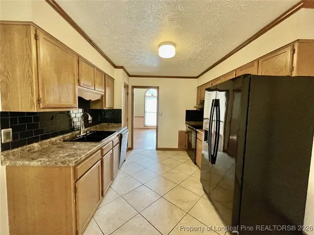 a kitchen with stainless steel appliances granite countertop a refrigerator a stove and a sink