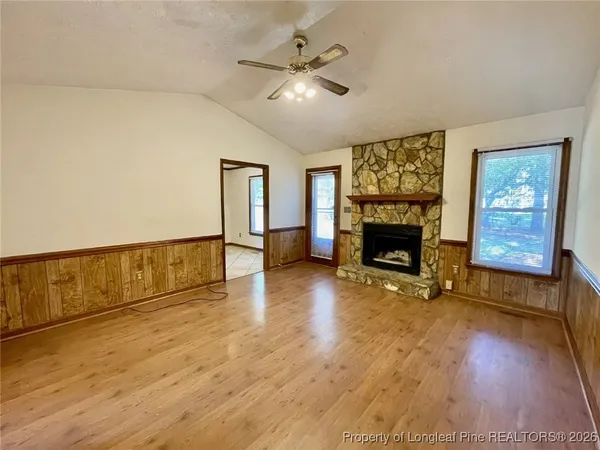 a view of an empty room with a fireplace and a window