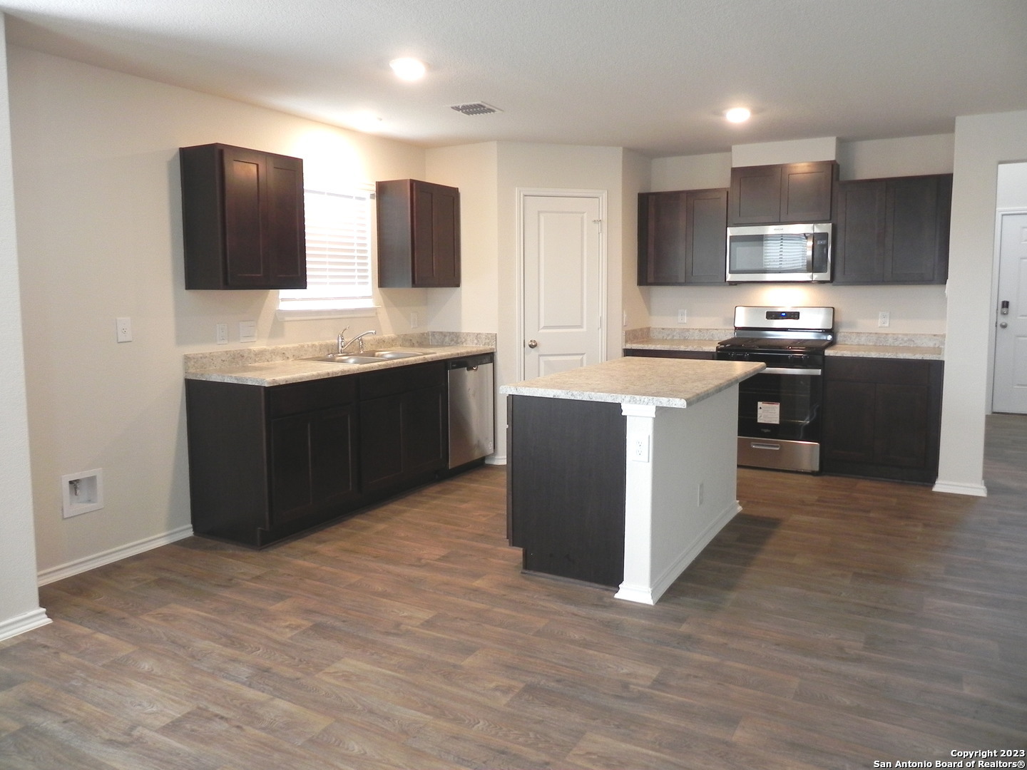 9506 Ranch Loop San Antonio, TX 78254 - Photo 4 of 25 a large kitchen with stainless steel appliances granite countertop a sink and cabinets