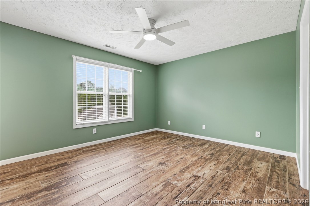 5113 Archer Road Hope Mills, NC 28348 - Photo 27 of 41 an empty room with wooden floor fan and windows