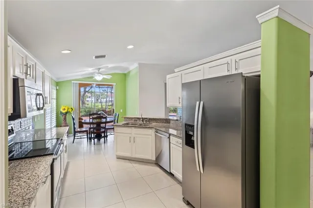 a kitchen with stainless steel appliances kitchen island granite countertop a refrigerator and cabinets
