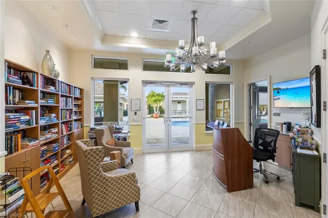 a living room with furniture a bookshelf and a chandelier