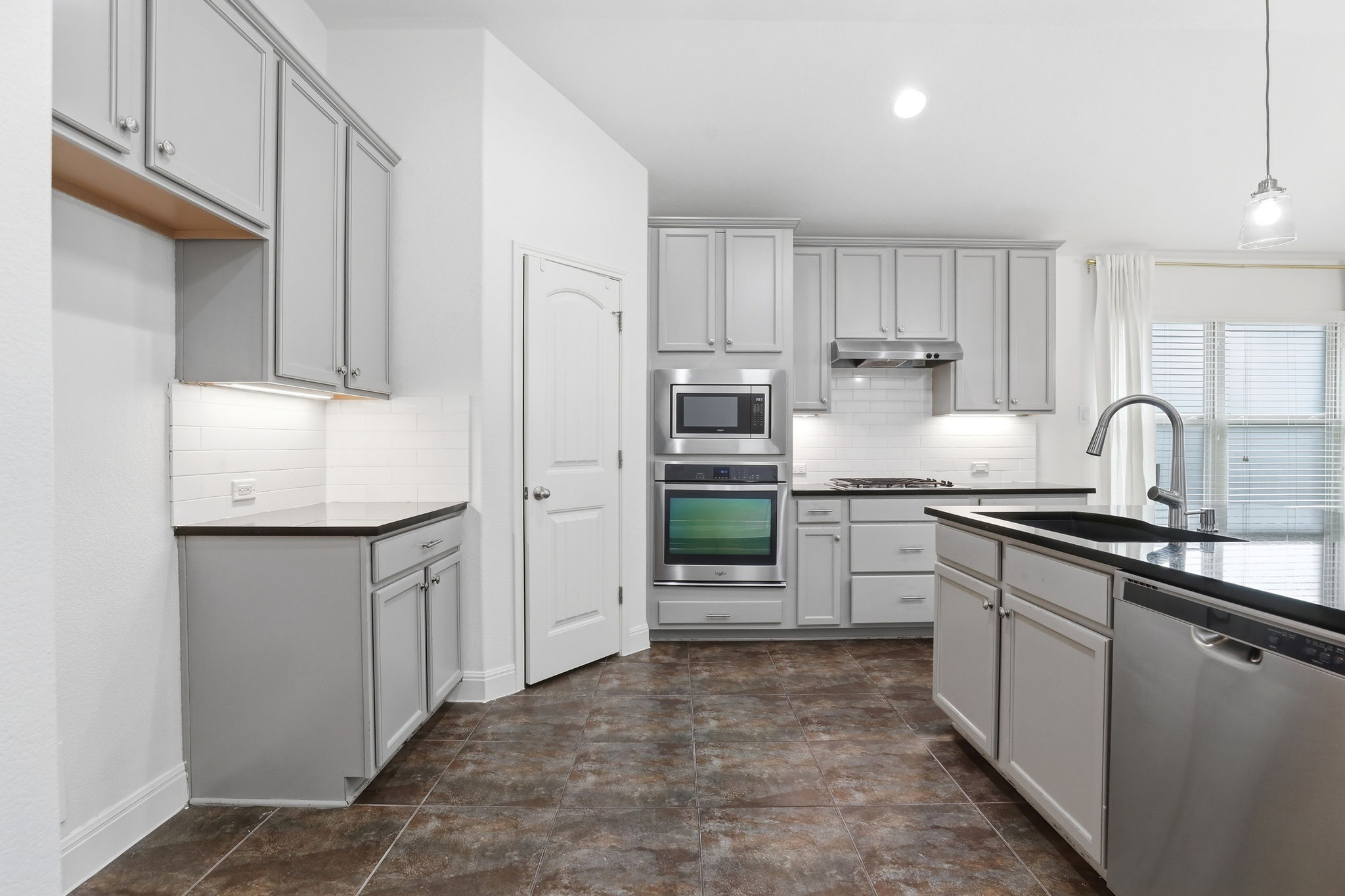 152 Stone View Trail Austin, TX 78737 - Photo 7 of 29 a kitchen with kitchen island granite countertop a sink stove and refrigerator