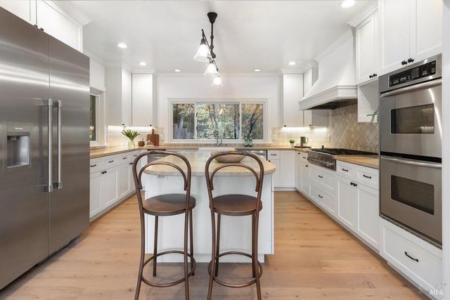 a kitchen with granite countertop a center island stainless steel appliances and cabinets