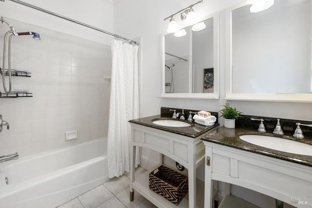 a bathroom with a granite countertop sink a mirror and a bathtub
