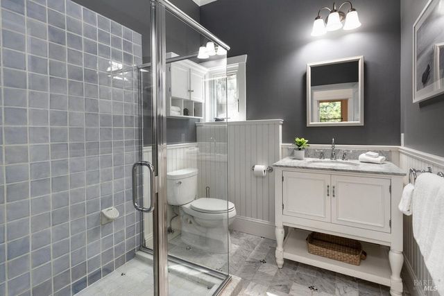a bathroom with a sink a toilet and shower