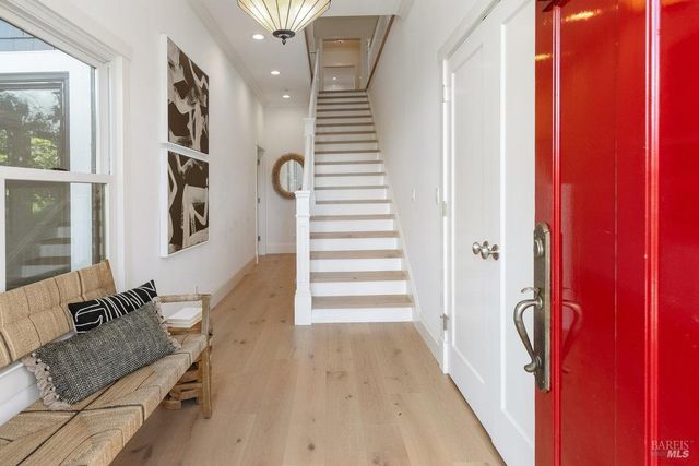a view of a hallway with wooden floor and staircase