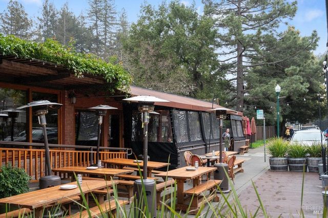 a view of a patio with table and chairs under an umbrella with wooden fence