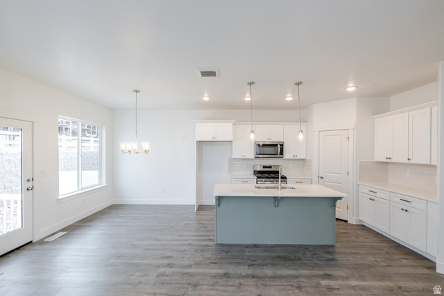 4741 Olive Avenue, Unit 406 Mapleton, UT 84664 - Photo 3 of 20 Kitchen featuring an island with sink, two tone cabinets, stainless steel appliances, hanging lights, and a breakfast bar