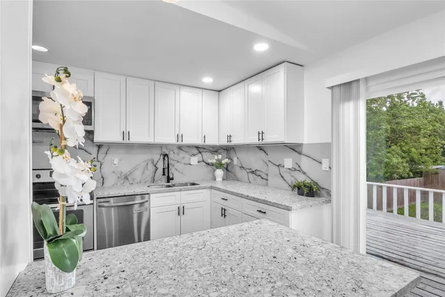 a kitchen with stainless steel appliances granite countertop a sink and cabinets