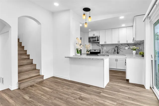 a kitchen with white cabinets and appliances