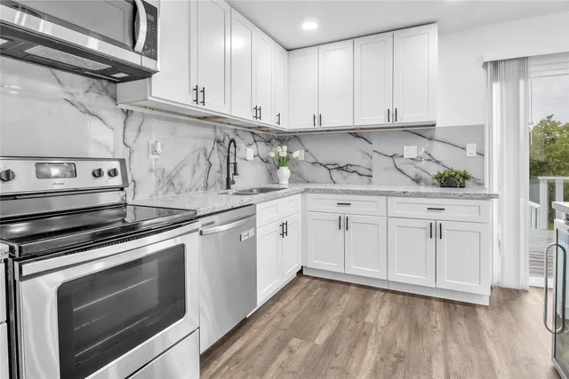 a kitchen with granite countertop white cabinets and white appliances