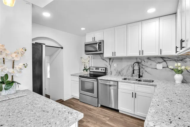 a kitchen with stainless steel appliances granite countertop a sink stove and refrigerator