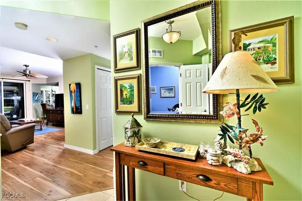 a room with lots of painting on the wall and a potted plant