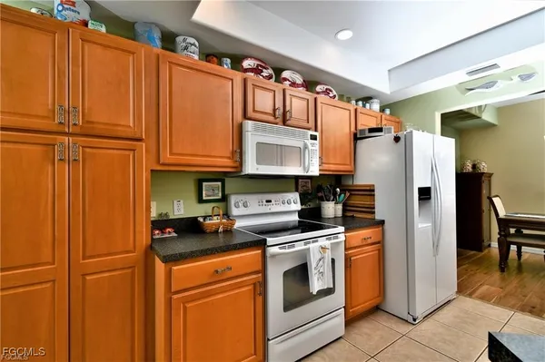 a kitchen with stainless steel appliances granite countertop a refrigerator a stove and a sink