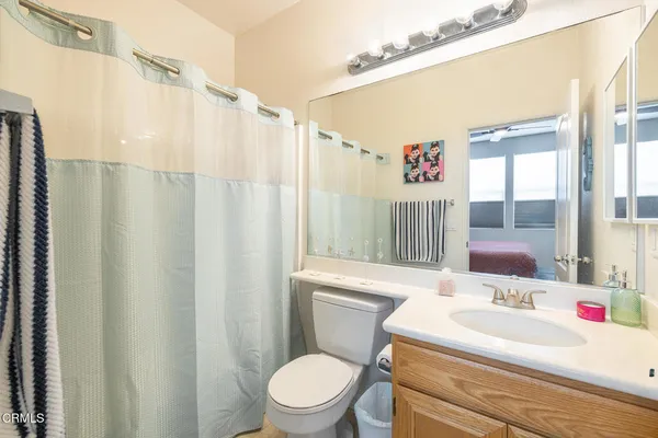 a bathroom with a sink a toilet and shower curtain